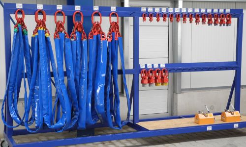 Blaues Gestell mit Hebeschlaufen, Anschlagmitteln und zwei gelben Lasthebemagneten.